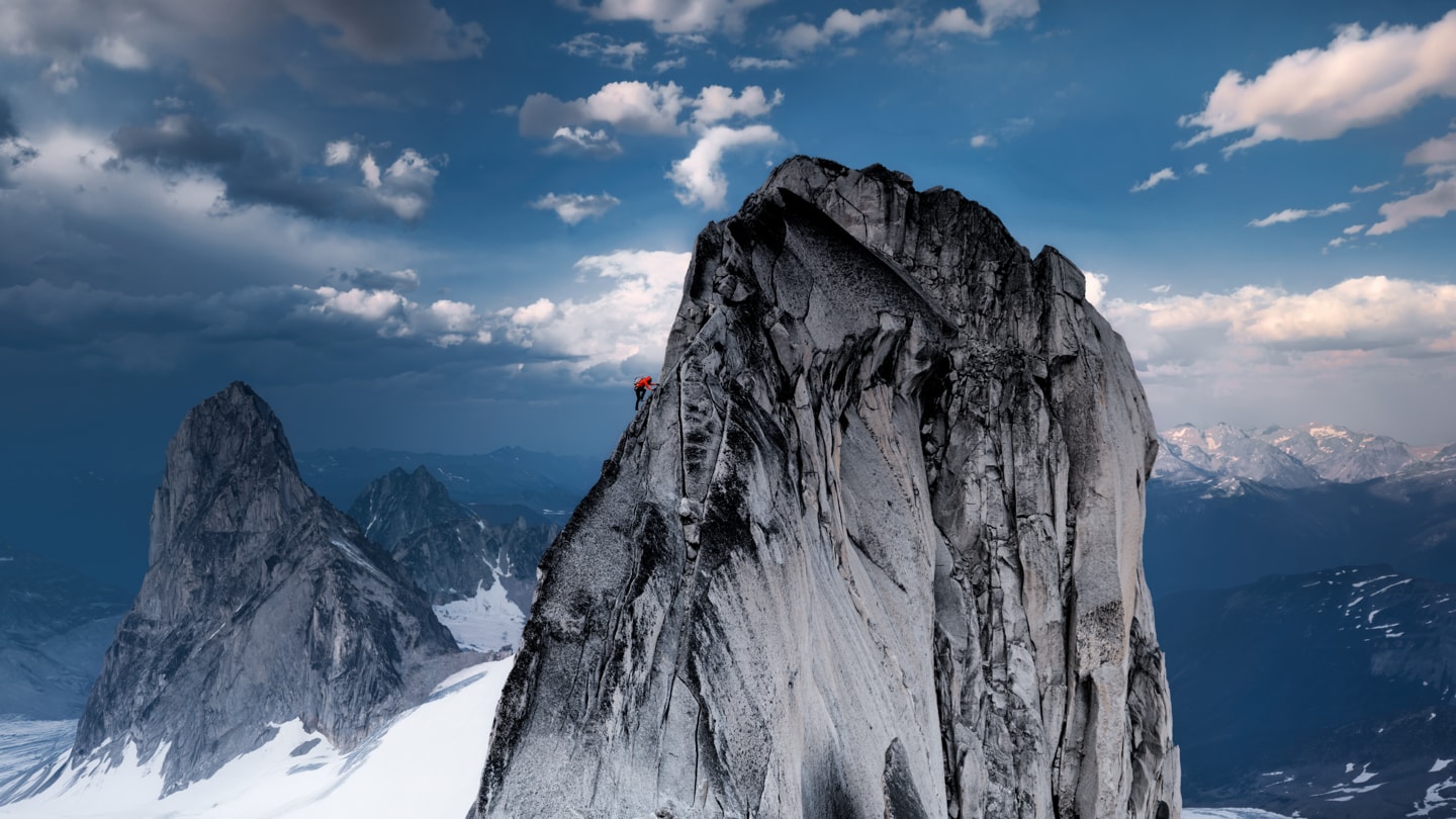 A photo shows a climber ascending a peak in the snow-covered Bugaboo Mountains.