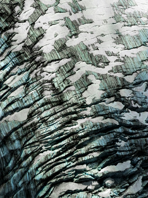 A photo shows the detailed pattern on the side of a glacier.