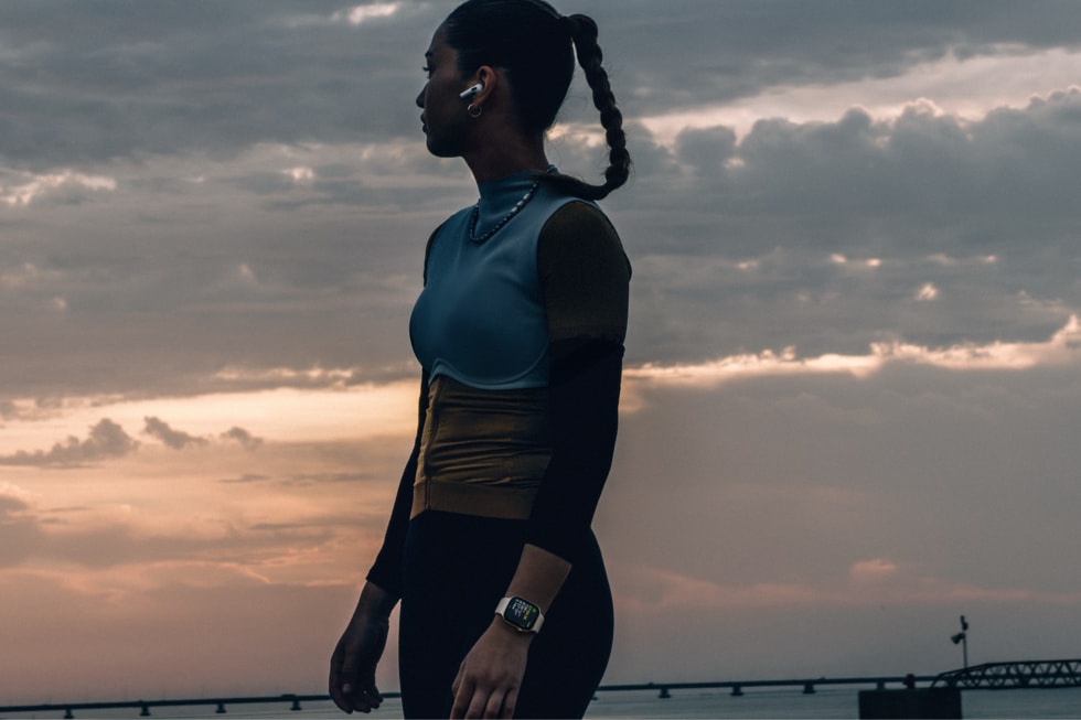 An Apple Watch Series 12 user is shown standing in profile outdoors.