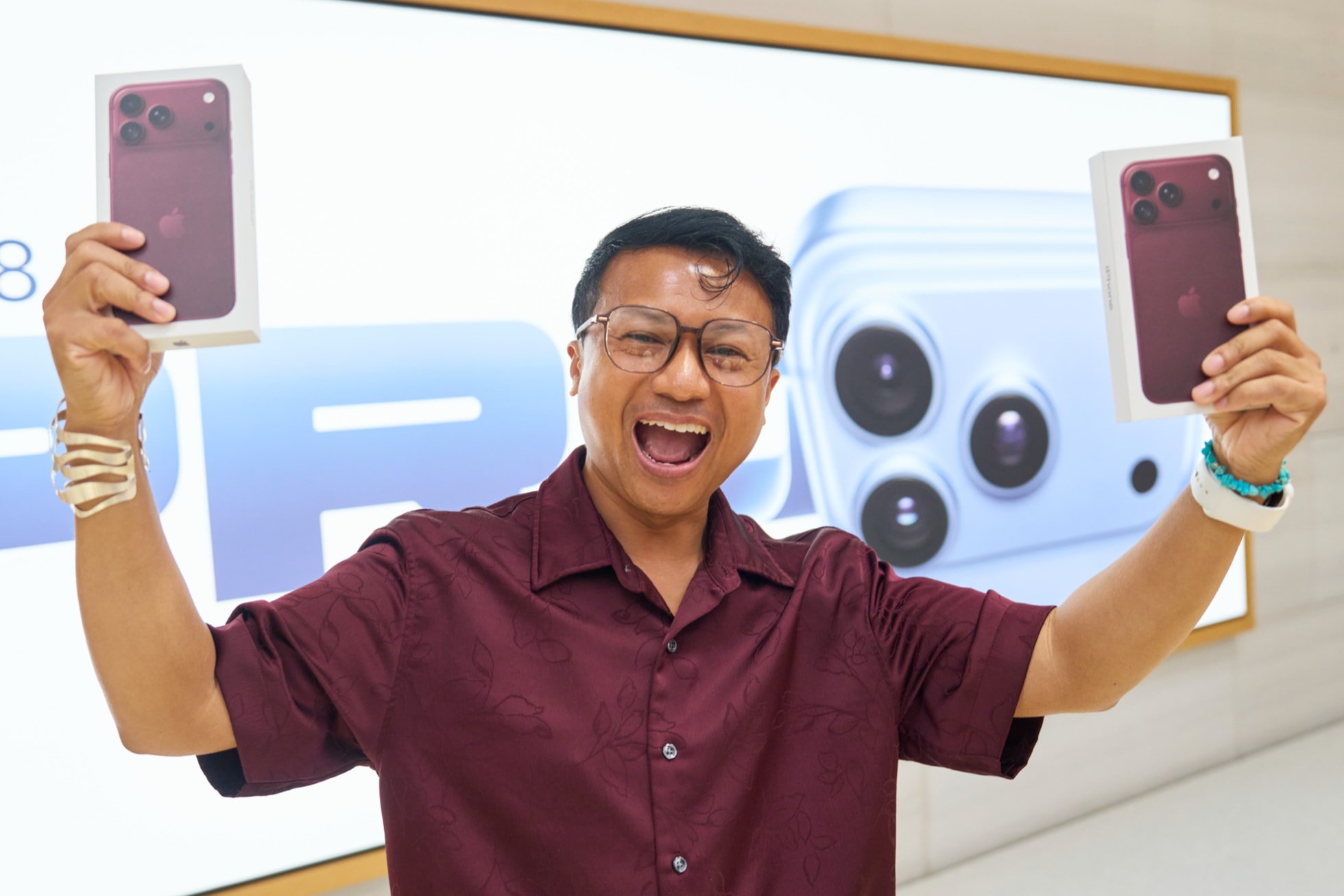 A customer holds up two iPhone 18 Pro purchases at Apple Fifth Avenue.