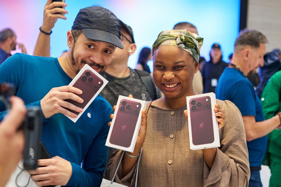 A customer and an Apple team member hold up their iPhone 18 Pro purchases at Apple Fifth Avenue.