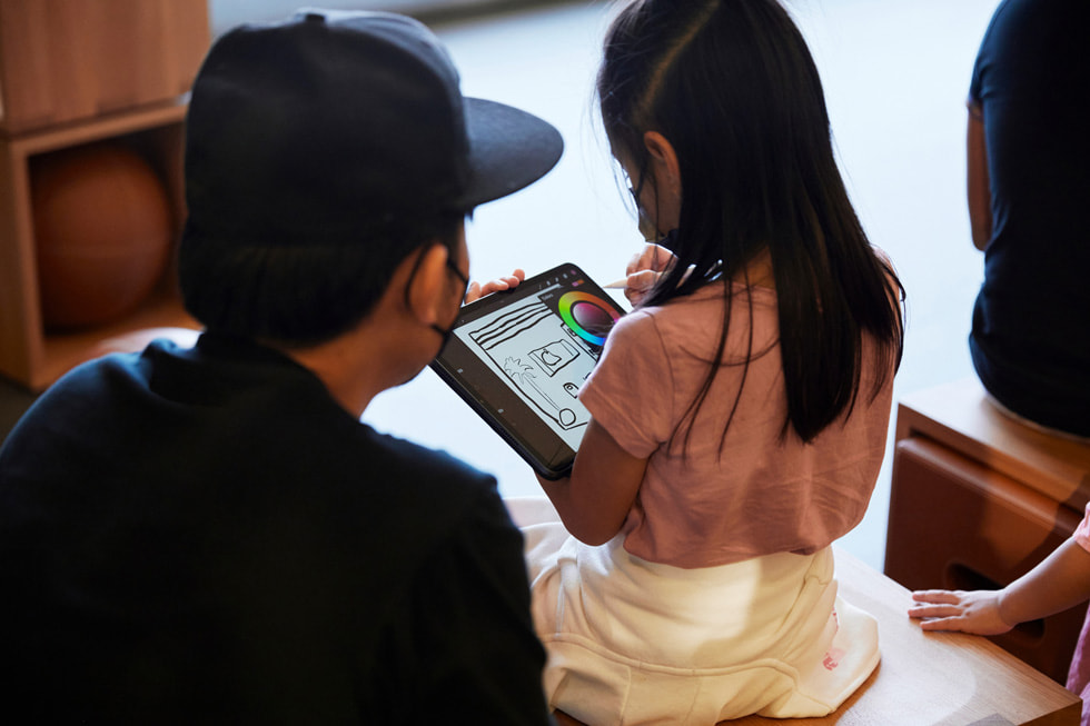 A young girl using an iPad in the Forum at Apple Al Maryah Island.