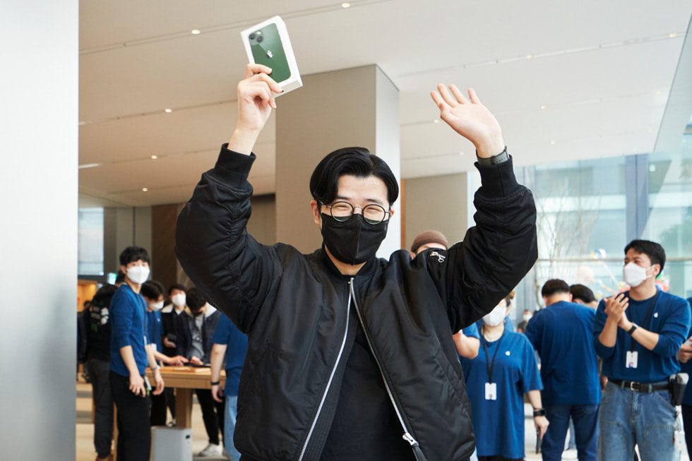 A customer shows off his new iPhone 13 during the store’s opening.
