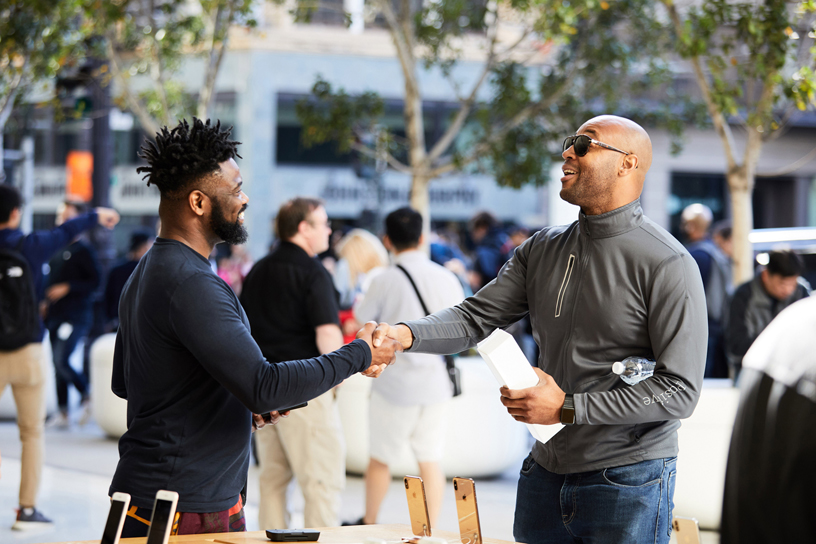 An Apple team member shakes hands with a customer.