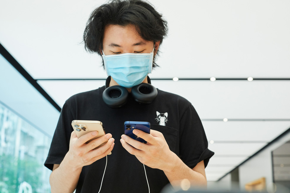 A customer at Apple Sydney compares iPhone 12 Pro Max to iPhone 12 mini.