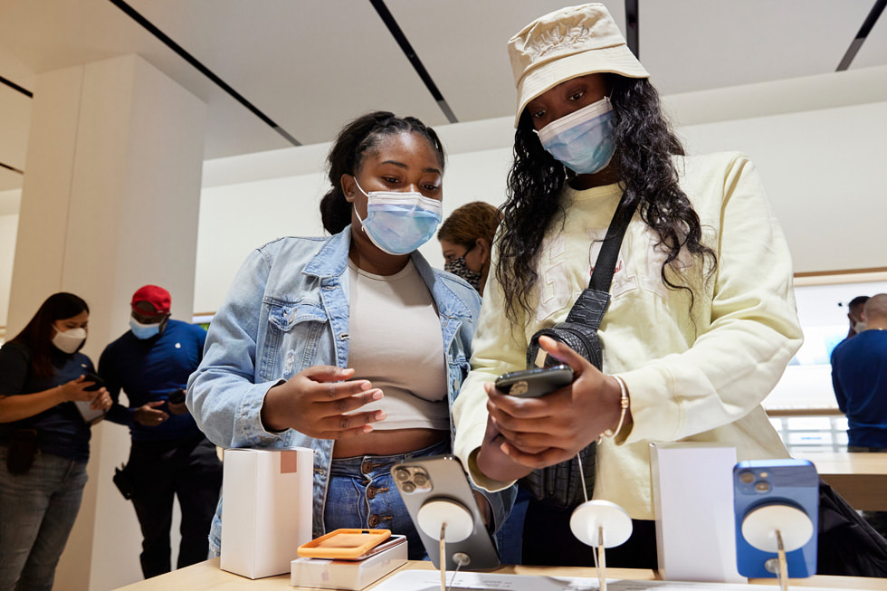 Two customers checking out the iPhone 13 and iPhone 13 Pro lineup.