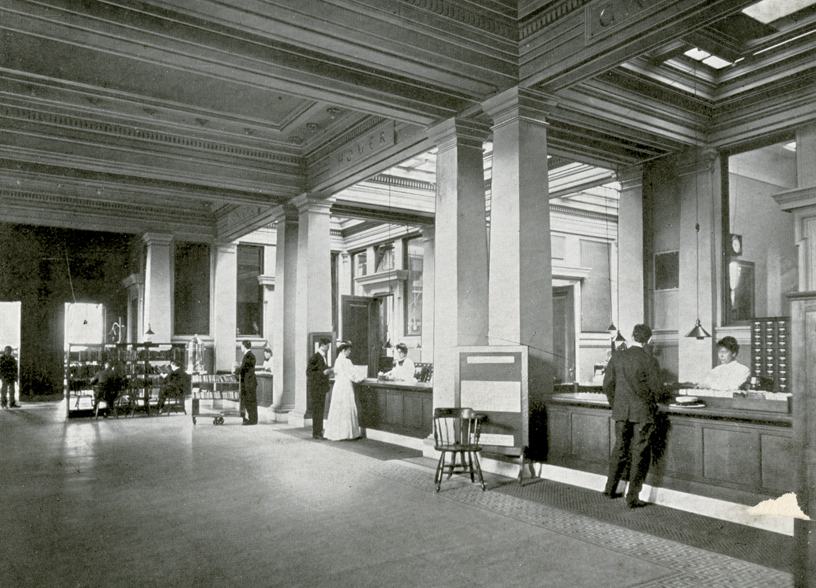 Archival photo of patrons at the library’s circulation desk.
