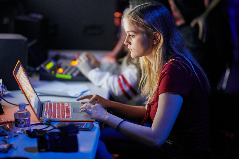 A student producer on computer backstage.