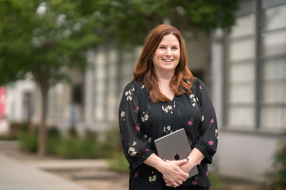 Jennifer Robbins, Downey Unified’s director of elementary education and an Apple Learning Coach, stands outdoor holding an iPad.