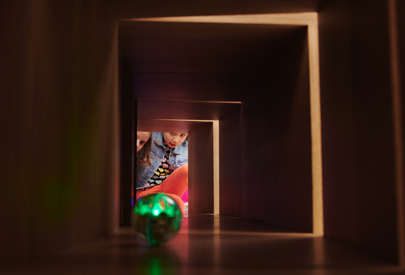 Två tjejer tittar genom en tunnel.