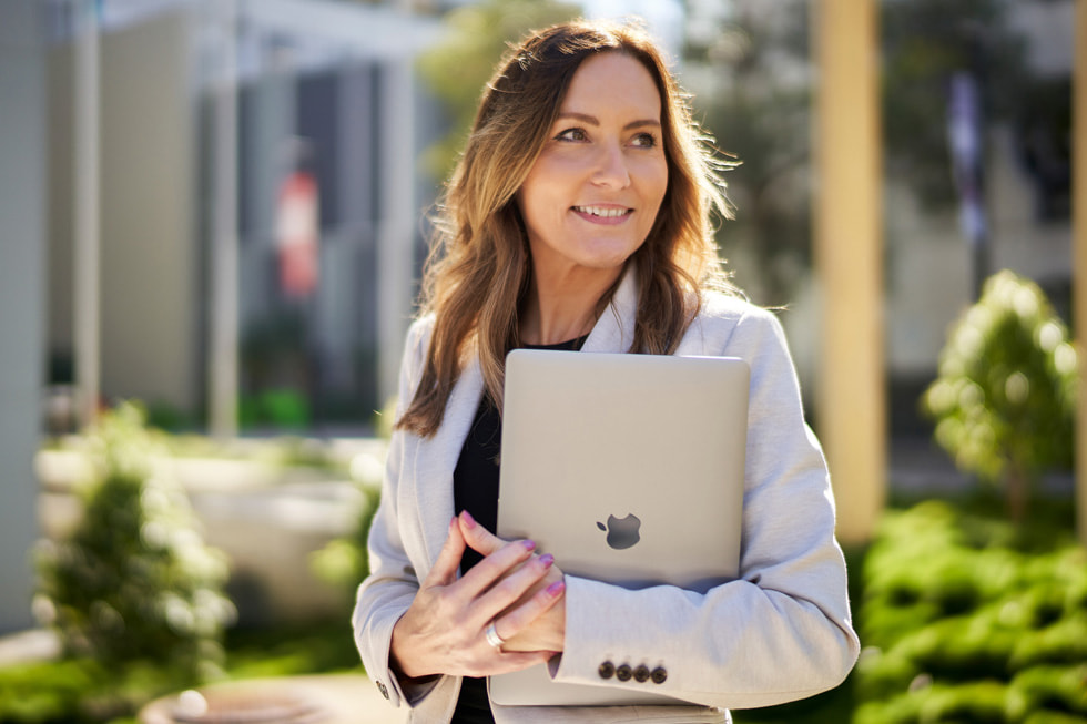 Jackie French of TAFE Queensland holding MacBook Air.