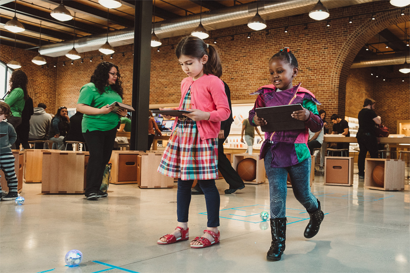 Two young girls using iPads.