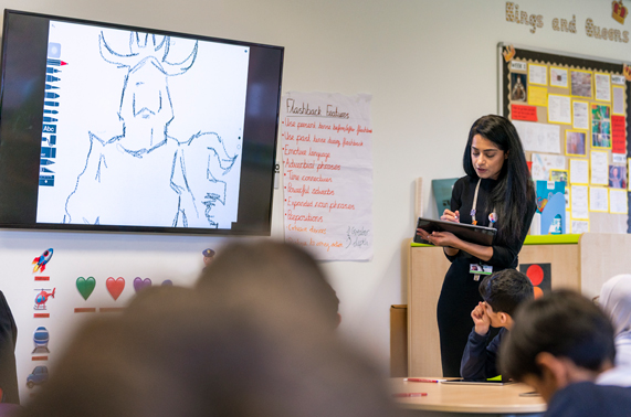 Un enseignant avec un iPad devant sa classe.