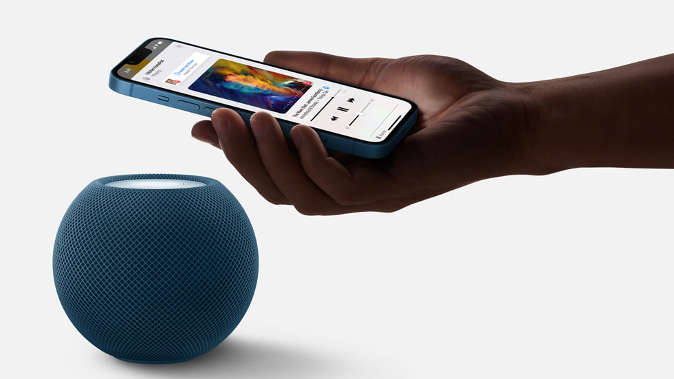 L’iPhone 13 mis à côté du HomePod mini pour transférer du contenu audio.