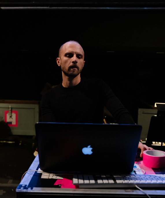 Enrico de Trizio standing behind a MacBook Pro.