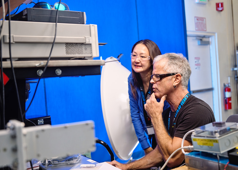 Two technicians are shown looking at machinery in an indoor setting.