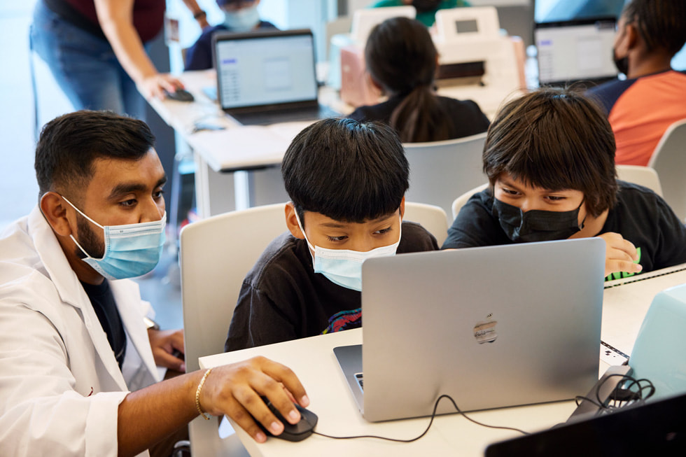 Two students are assisted by an instructor in a computer lab at California State University, Dominguez Hills.