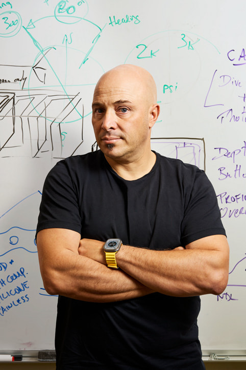 Huish Outdoors vice president of product development Andrea Silvestri and design stands in front of a whiteboard.  