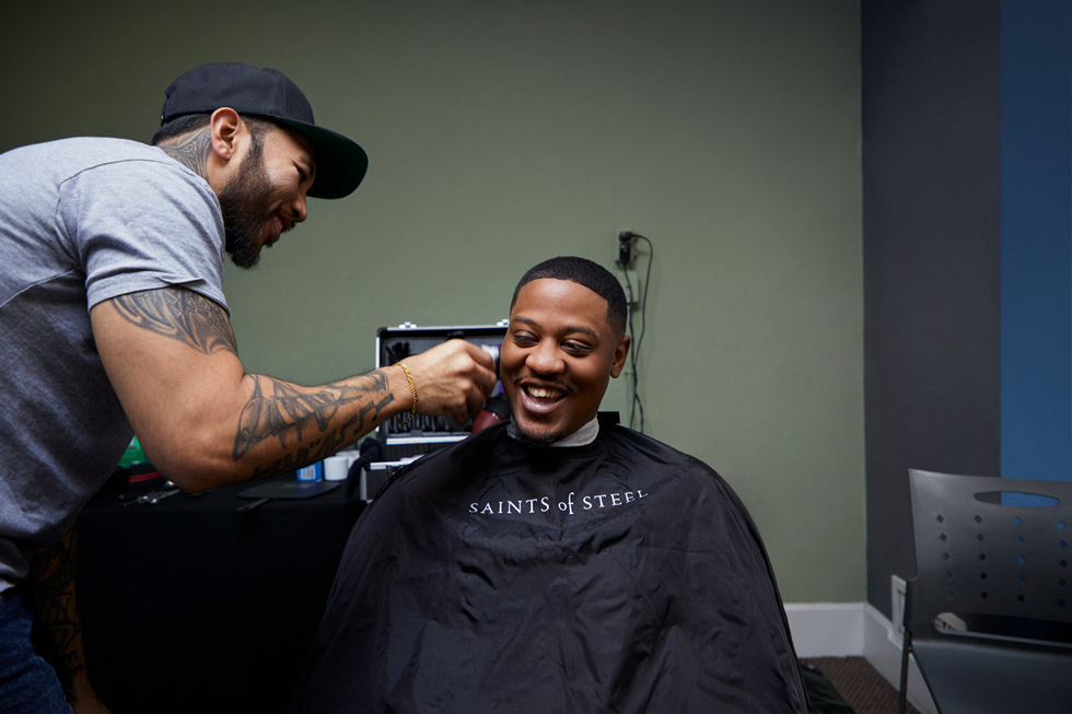 A barber giving a young man a haircut.