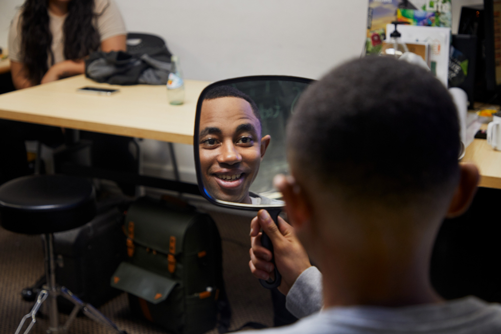 A young man admiring his haircut.