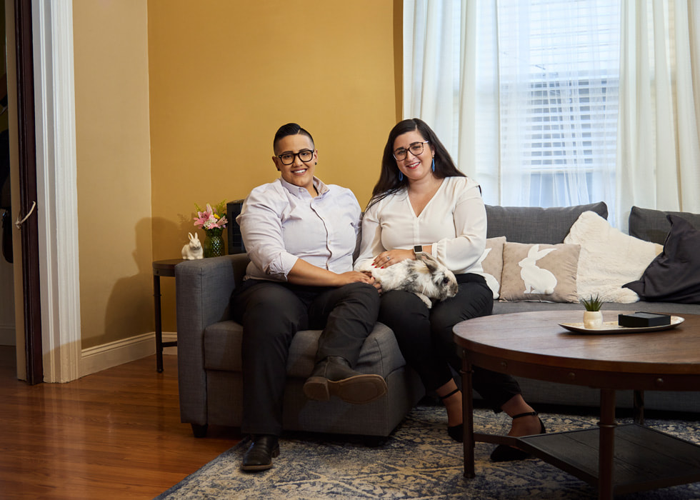 Taylor Mestres and Keteria Lara sit on a couch in their new home.