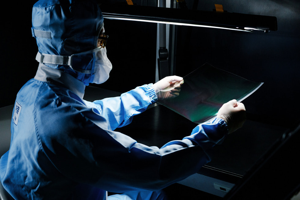 保護具を着た作業員がラボで作業しているところ。