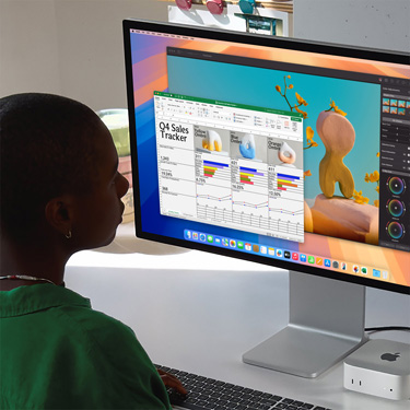 女子坐在工作桌前，在 Mac 上使用 Excel 試算表，Excel 試算表的內容是第四季銷售追蹤表。Excel 試算表視窗後方是 Pixelmator Pro 視窗