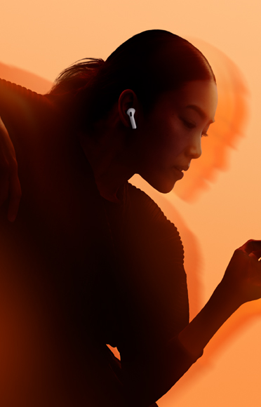 A person wearing AirPods 5, arms bent, multicolour background