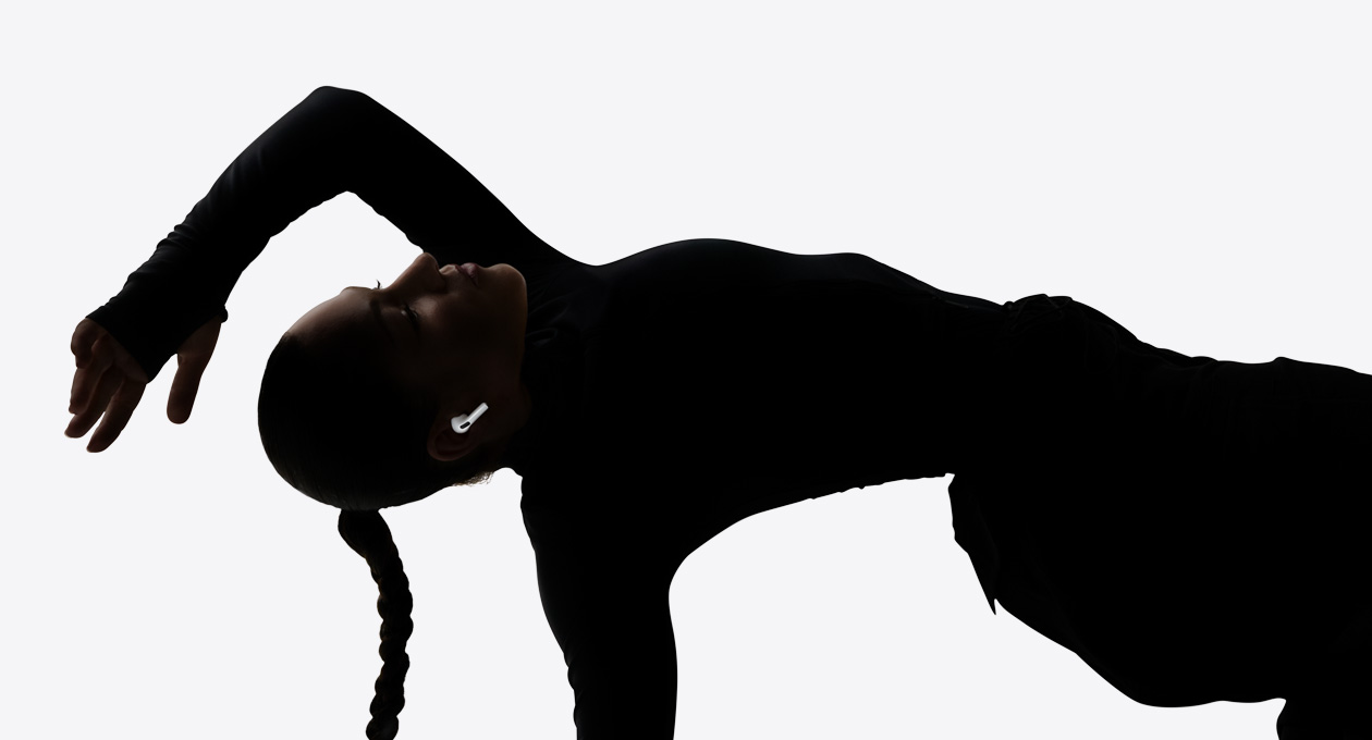 Kulağına AirPods Pro 3 takmış bir dansçı ellerini kullanmadan dinleme deneyiminin keyfini çıkarıyor