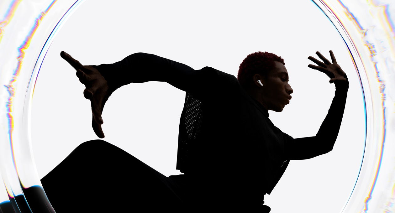 Personne portant des AirPods Pro 3 qui danse au son de la musique avec les bras déployés