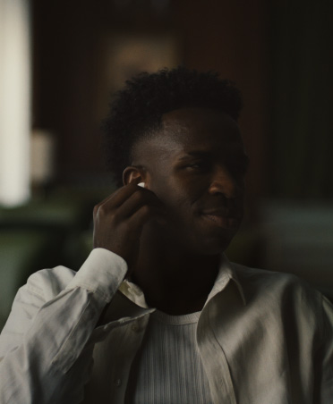 AirPods Pro 3, una persona con una camisa blanca pellizca el auricular derecho