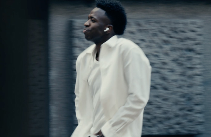 Una persona con una camisa blanca aparece al aire libre, se ve el auricular izquierdo de unos AirPods Pro 3