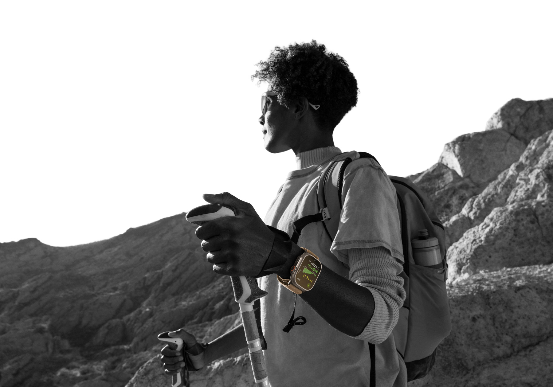 A person hiking in the desert wearing Apple Watch Ultra 4, screen shows elevation metrics