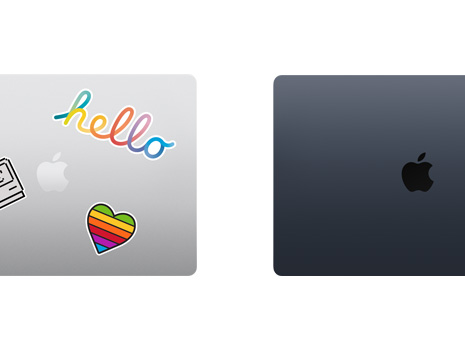 Vista desde arriba de dos portátiles Mac cerrados, uno con pegatinas.