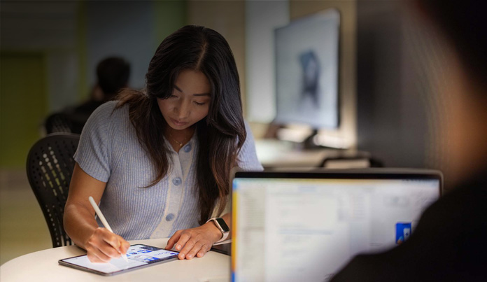 Studente dell’università che usa Apple Pencil per prendere appunti su un iPad in un laboratorio di tecnologia