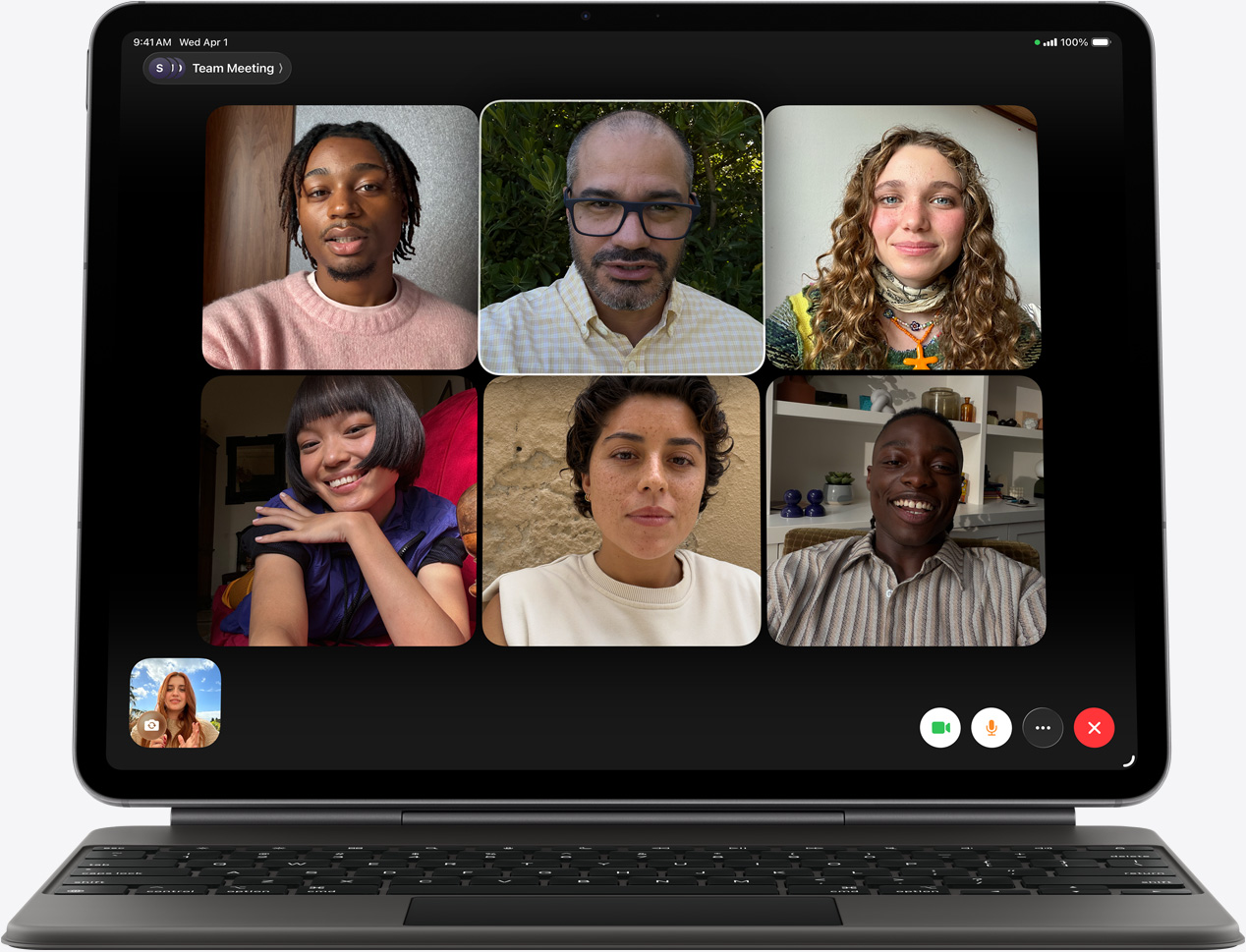 Vista frontal do iPad Air, Magic Keyboard, na cor preto, chamada do FaceTime no ecrã com vários participantes visíveis
