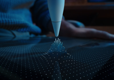 Apple Pencil Pro virado para baixo na direção do ecrã. O ecrã está coberto de pontos que sobem e seguem a ponta do Apple Pencil Pro para mostrar como a funcionalidade Passagem sobre o ecrã liga o Apple Pencil Pro ao iPad antes de pousar no ecrã.