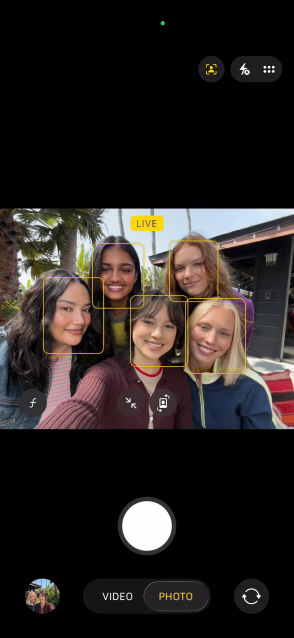 Skjermen på en iPhone 17 viser en gruppeselfie med Sentrering-funksjonen for bilder.