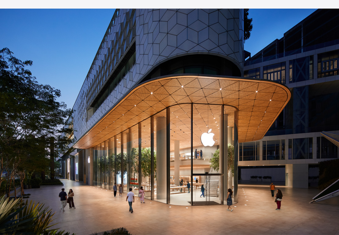 Apple Store bei Nacht, Glasfenster, innen beleuchtet, Apple Logo mittig oben auf der Eingangstür.