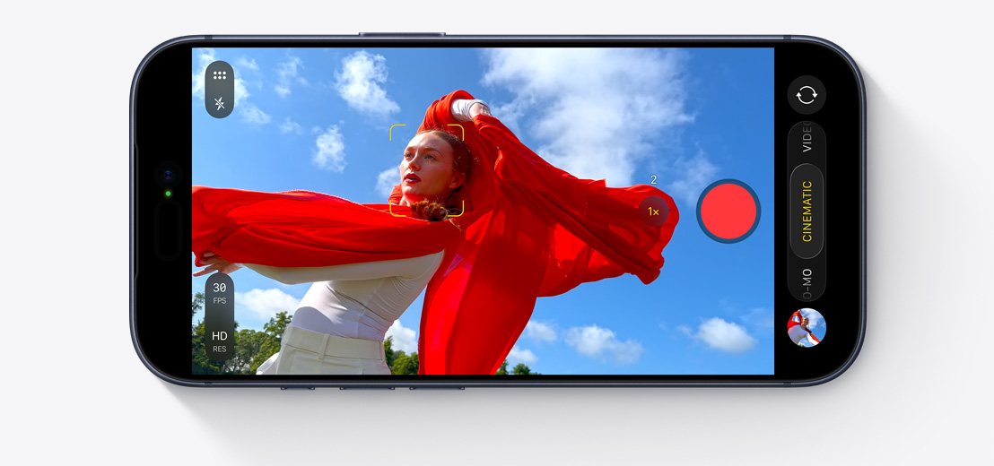 iPhone exterior față, dispus orizontal, captarea unui selfie cu două persoane în mașină cu camera frontală Center Stage, pătrate galbene conturând fețele pentru a arăta încadrarea automată