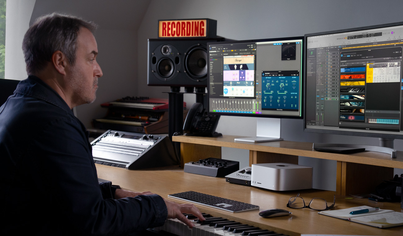 Một nhạc sĩ sử dụng đàn piano để tạo bản mix âm thanh với Mac Studio và Studio Display