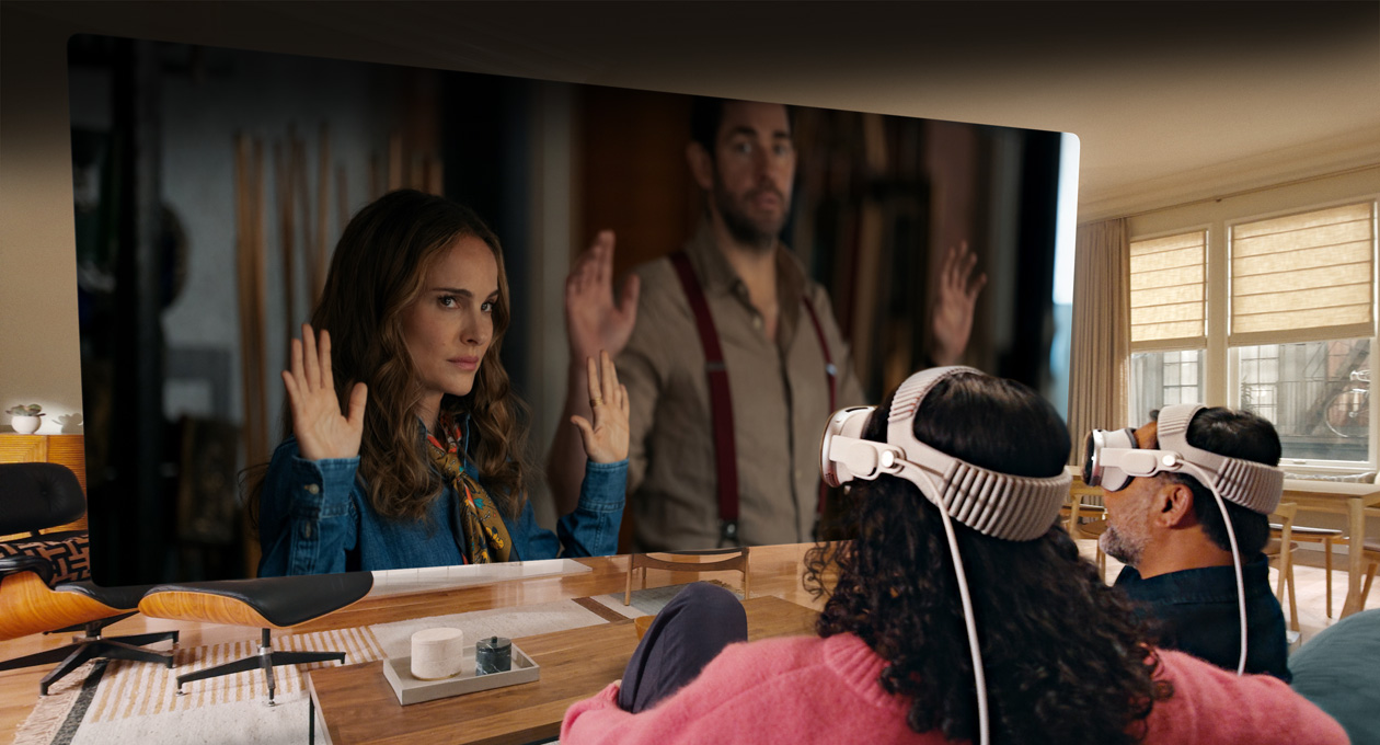 Two people both wearing Apple Vision Pro sit side by side on a couch watching: Fountain of Youth movie, displayed on a screen stretching across the room